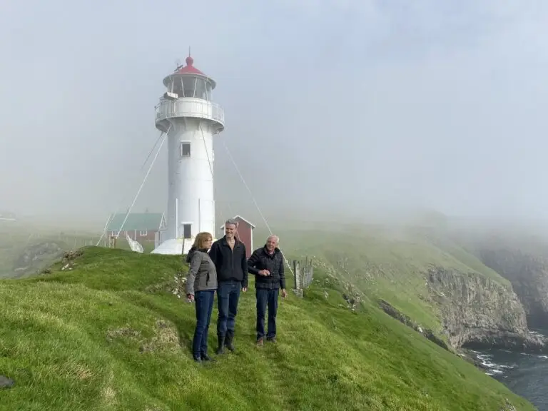 Two guests at the misty Akraberg lighthouse on a foggy Atlantic day