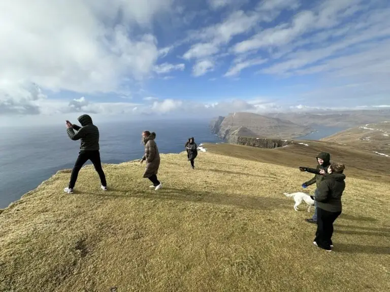 Group of guests on the Akraberg hilltop enjoying panoramic views of the Atlantic
