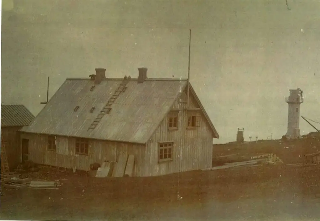Historic photograph of the Akraberg lighthouse station showing the keeper's house and lighthouse tower