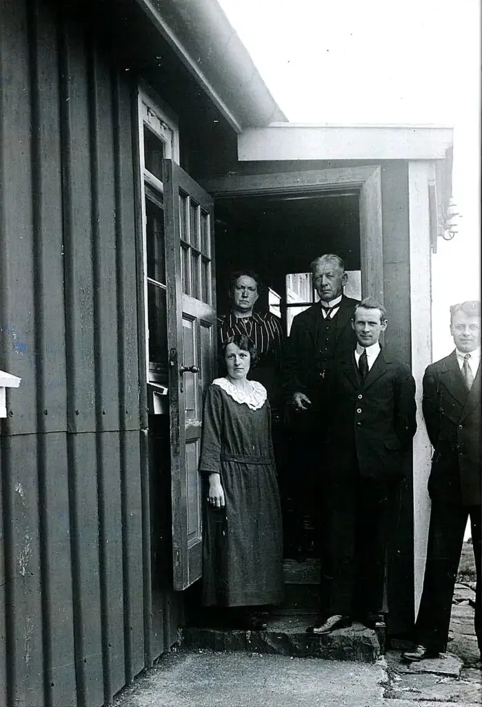 Historical photograph of Akraberg lighthouse keepers and their family posed in a doorway